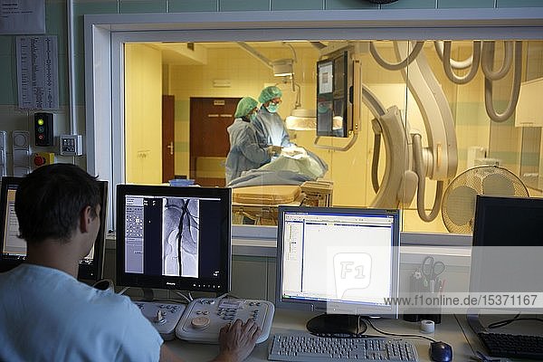 Interventionelle Radiologie  Arzt überwacht Kollegen während einer Operation am Monitor  Karlovy Vary  Tschechische Republik  Europa