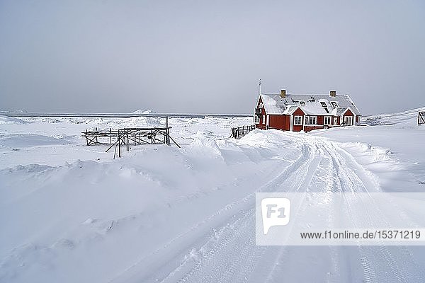 Winterlandschaft mit einem roten Holzhaus in Ilulisat  Avannnaata Communia  Grönland  Dänemark  Nordamerika