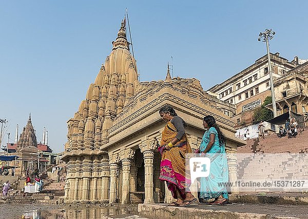 Zwei Frauen in traditioneller Sari-Kleidung vor dem schiefen Ratneshwar Mahadev-Tempel  Varanasi  Uttar Pradesh  Indien  Asien