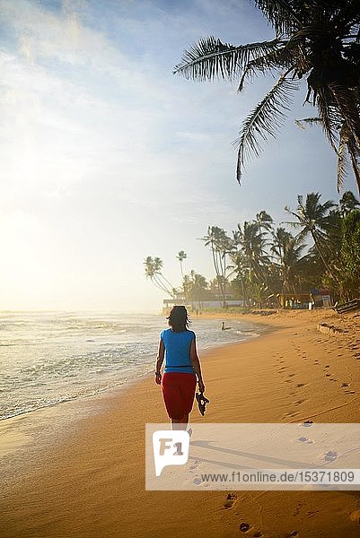 Junge Frau beim Spaziergang am Strand von Hikkaduwa  Sri Lanka  Asien
