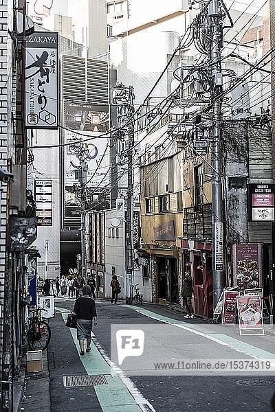 Straßenszene  kleine Straße mit Geschäften  chaotischen Stromkabeln und japanischen Schildern  Shibuya  Tokio  Japan  Asien
