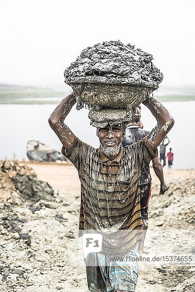 Ziegeleiarbeiter trägt Lehm in einem Korb auf dem Kopf  Dhaka  Bangladesch  Asien