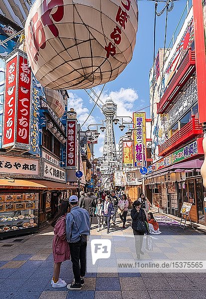 Viele bunte Werbeschilder in einer Fußgängerzone mit Geschäften und Restaurants  Einkaufszentrum  Rückseite Tsutenkaku Tower  Shinsekai  Osaka  Japan  Asien