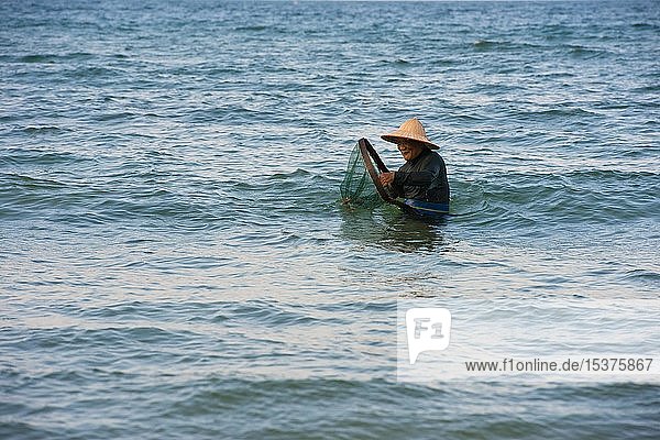 Krabbenfischer mit Strohhut im Wasser  Strand Cua Dai  bei Hoi An  Vietnam  Asien