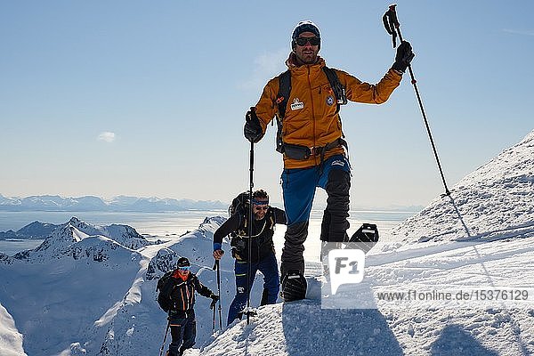 Ski mountaineers ascending to Rundfjellet  behind the Norwegian Sea  Svolvaer  Austvågøy  Lofoten  Norway  Europe