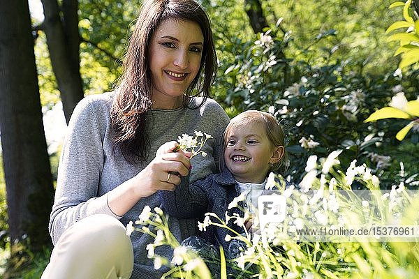 Mutter sitzt mit kleiner Tochter auf einer Blumenwiese  Tschechische Republik  Europa