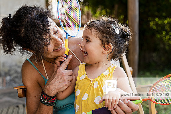 Großmutter spielt mit kleinen Mädchen und Badmintonschlägern im Freien