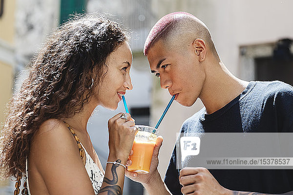 Junges Paar trinkt gemeinsam Fruchtsaft