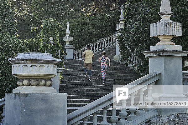 Mann und Frau rennen auf einer Treppe
