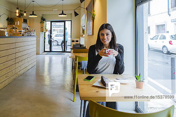 Portrait of smiling young woman sitting in a cafe