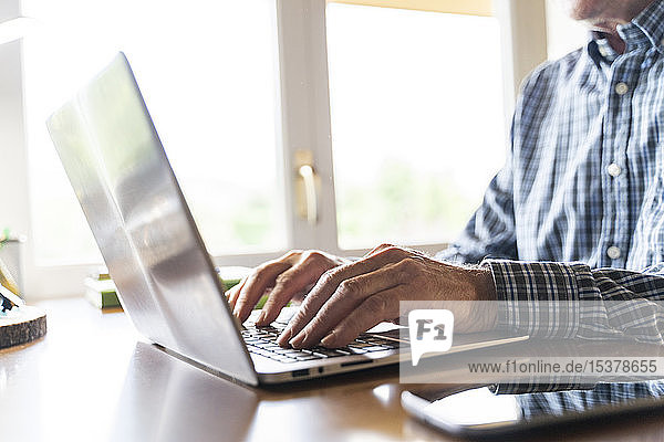Älterer Mann benutzt Laptop zu Hause
