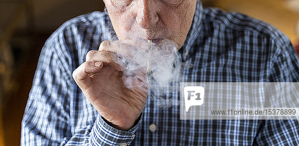 Älterer Mann raucht zu Hause Marihuana