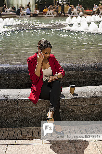 Businesswoman on the phone checking the time London UK