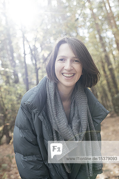 Porträt einer lächelnden Frau im Herbstwald