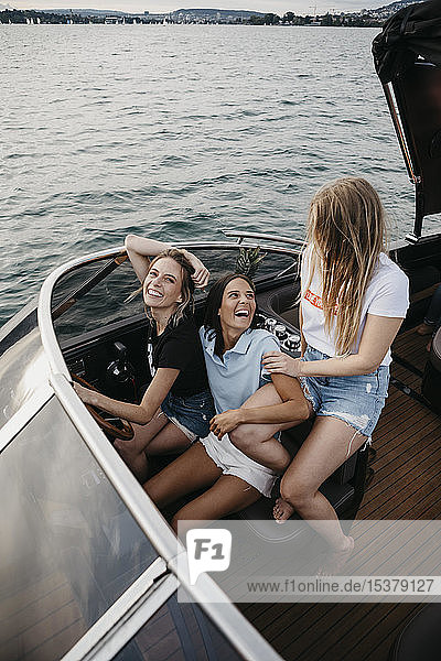 Happy female friends having fun on a boat trip on a lake