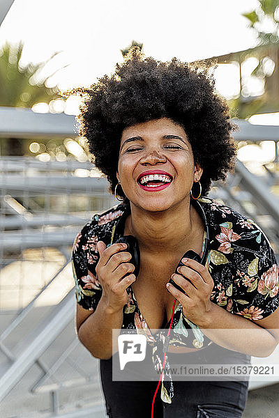 Portrait of laughing Afro-American woman with headphones