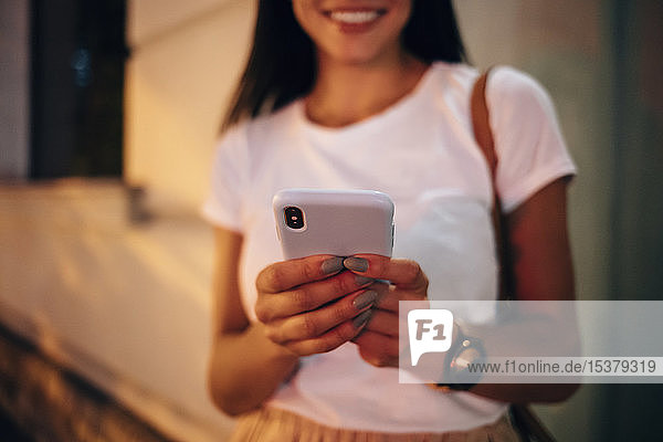 Young woman using smartphone in the city at night