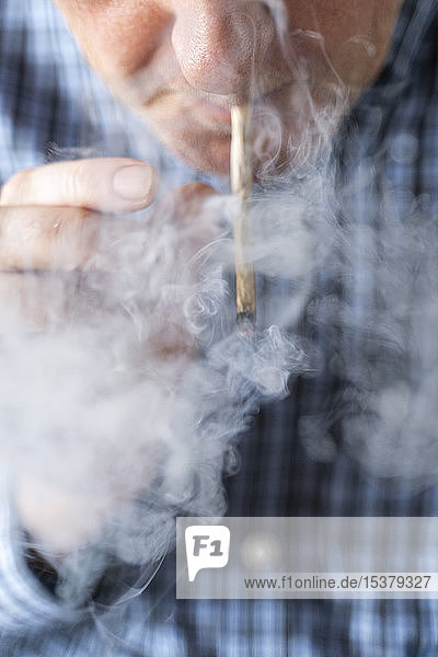 Älterer Mann raucht zu Hause Marihuana