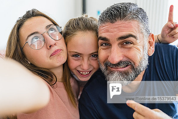 Selfie eines glücklichen Vaters mit zwei Töchtern