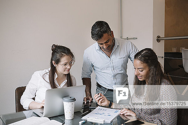 Colleagues working together at table in office