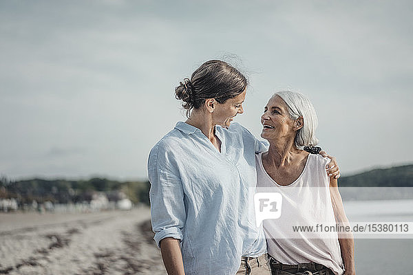 Mother and daughter spending a day at the sea  embracing on the beach
