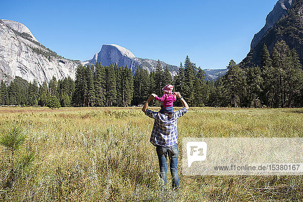 Rückenansicht eines Vaters  der seine kleine Tochter auf den Schultern trägt  Yosemite National Park  Kalifornien  USA
