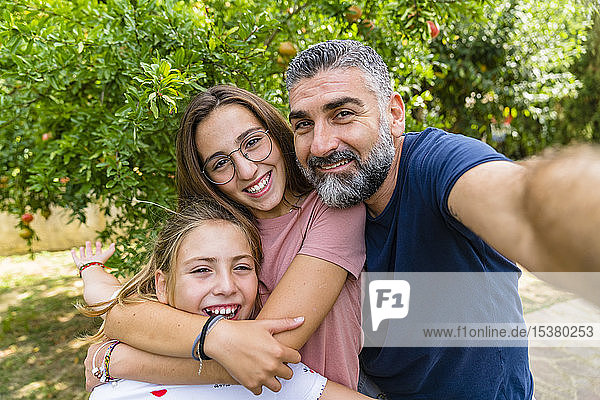 Glücklicher Vater mit zwei Töchtern  die Selbsthilfe im Garten betreiben
