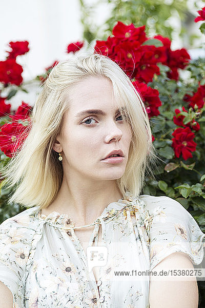 Portrait of blond young woman wearing summer blouse with floral design