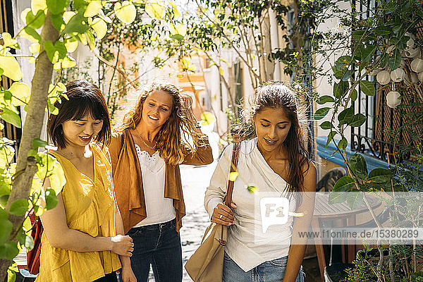 Three female friends in a picturesque alley in the city