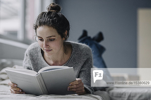 Porträt einer jungen Frau  die zu Hause ein Buch liest