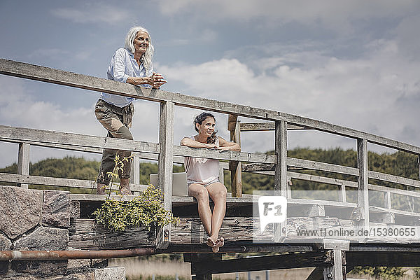 Mutter und Tochter beim Blick von einer Brücke