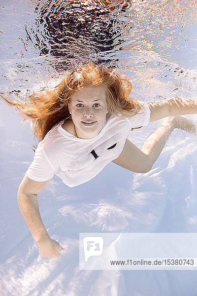 Porträt einer Teenagerin im T-Shirt beim Tauchen unter Wasser