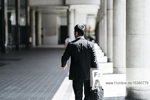 Rear view of young businessman walking in the city