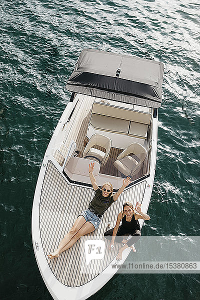 Top view of happy female friends on a boat trip on a lake