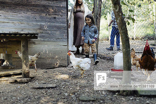 Familie in einem Hühnerstall auf einem Biohof