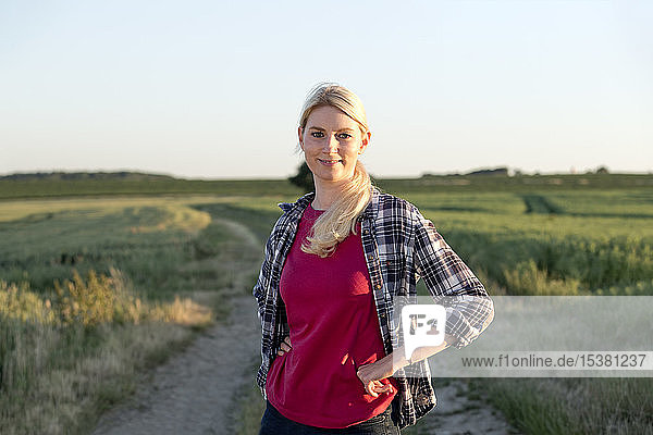 Porträt einer lächelnden Frau  die auf einem Feldweg steht