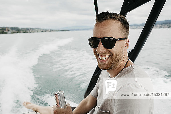 Happy man wearing sunglasses on a boat trip on a lake
