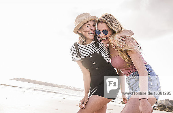 Two girlfriends having fun  walking on the beach