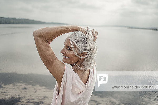 Weißhaarige ältere Frau posiert am Meer