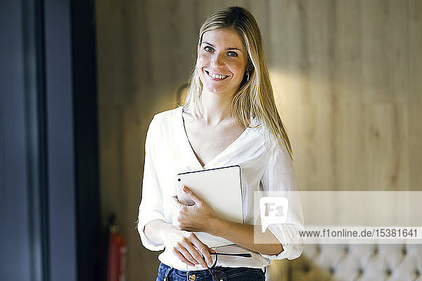 Porträt einer lächelnden Geschäftsfrau  die ein Tablett hält