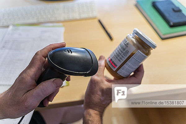Mann scannt Etikett auf einem Schraubdeckelglas