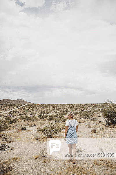 Junge Frau wandert durch Wüstenlandschaft  Joshua-Tree-Nationalpark  Kalifornien  USA