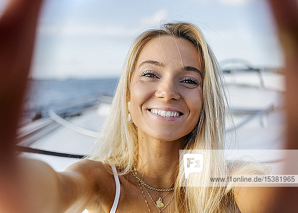 Junge schöne Frau  die auf einem Segelboot ein Selfie macht