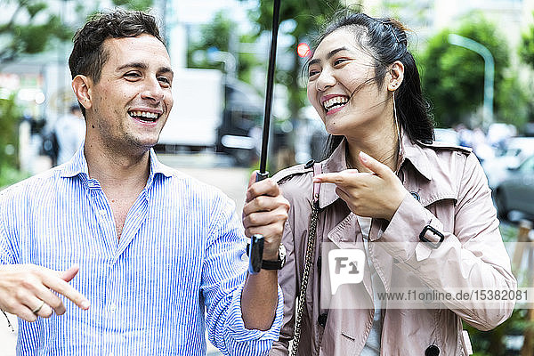 Glückliches Paar mit Regenschirm amüsiert sich in Ginza  Tokio  Japan