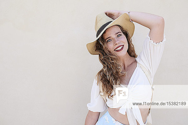 Porträt einer schönen lächelnden jungen Frau mit Hut