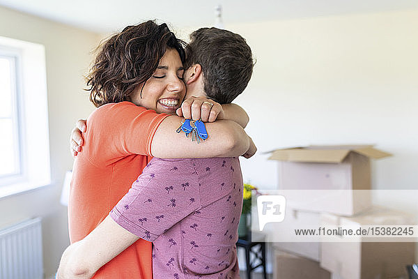 Glückliches Paar umarmt sich in neuem Zuhause