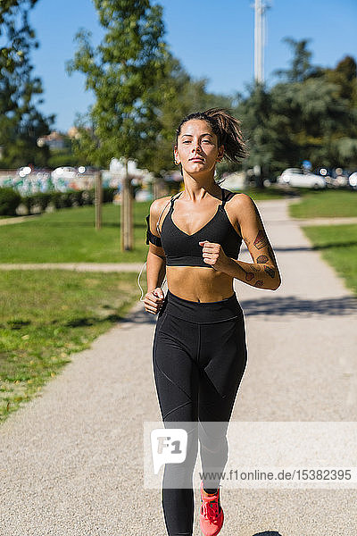 Porträt einer jungen Frau beim Laufen in einem Park