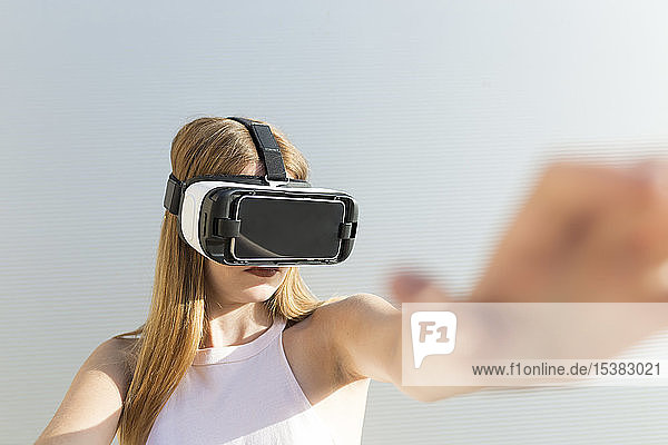 Young woman using Vr googles  reaching with her hand