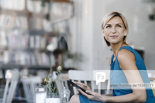 Geschäftsfrau sitzt im Café und benutzt ein digitales Tablet