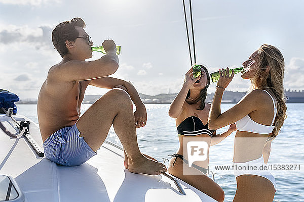 Drei junge Freunde genießen einen Sommertag auf einem Segelboot